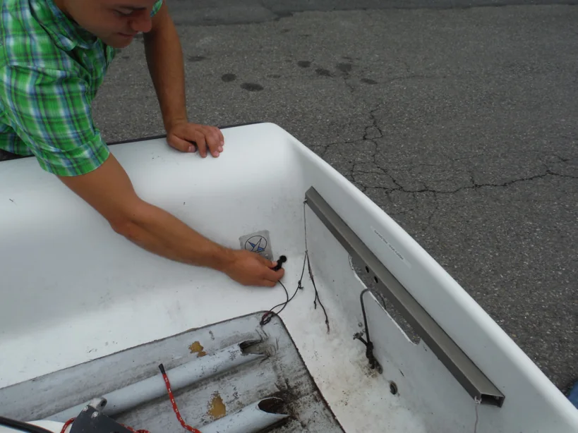 Sailor installing a side-tank plug inside an FJ