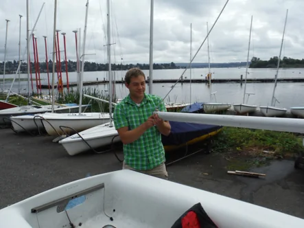 Sailor carefully lowering the boom into the FJ
