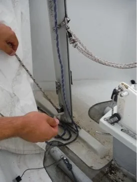 Tensioning the jib halyard beside the mast