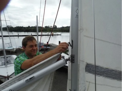 Main sail being fed into the mast slot