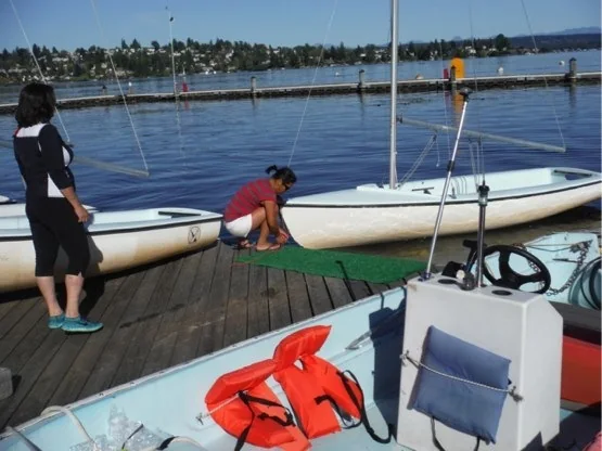 Two sailors sliding the stern of an FJ into the water