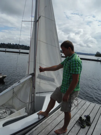 Crew member holding the shroud while the boat is boarded