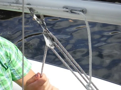 Sailor tightening the boom vang